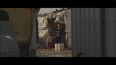 L'eau courante n'est pas disponible dans les camps, ici une jeune fille attend pour remplir des bidons.